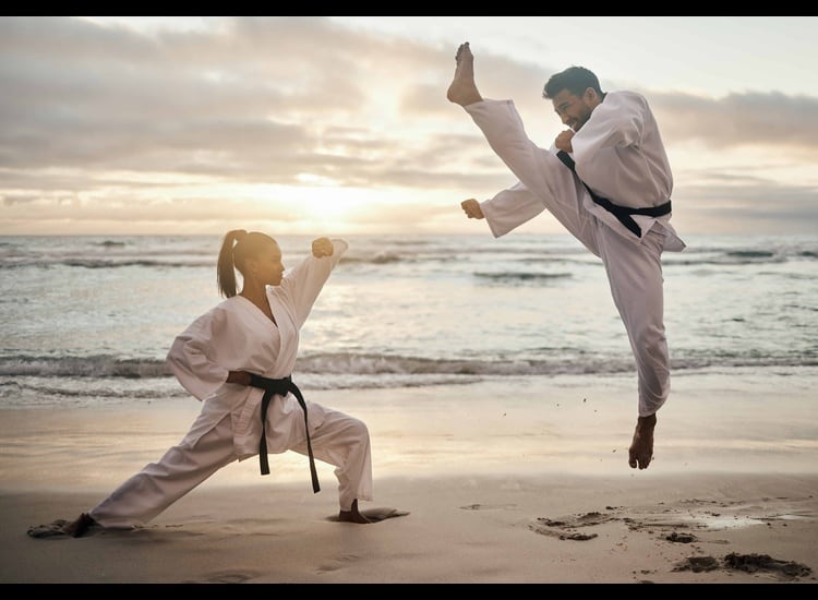 People training karate on the beach.